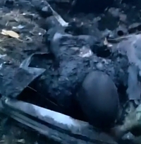  Ukrainian soldier shows a burned body of a Russian soldier 