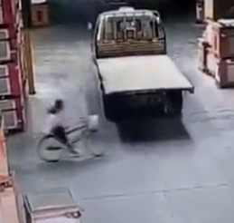 Girl riding a bike gets part of her body crushed by reversing truck