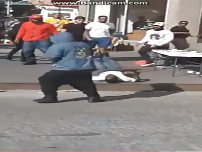 Street vendor beaten by men on the floor in front of his wife and children