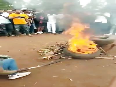 MAN BURNING WHILE PEOPLE ARE SINGING AND DANCING
