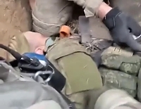Ukrainian soldiers process a captured Russian serviceman
