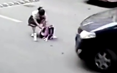 Little Chinese schoolgirl check up her bag in middle of street 