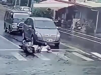 A man collapses from his scooter and a car runs over him.
