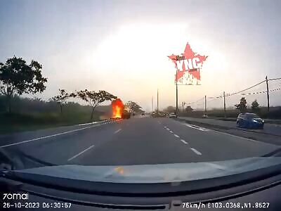 A motorcycle bursts into flames upon impact with on truck.