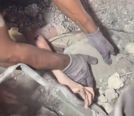 Brave Palestinian Little girl tries to move the rubble that is completely burying her.