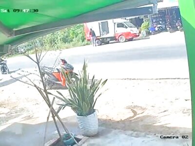 Man falls off his scooter in front of a truck and gets dragged down th