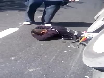 motorcyclist body trapped under the tires of big truck