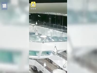Woman trips and falls face first into a shark tank in Chinese mall