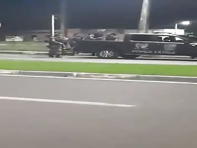 Brazilian police throwing criminal in the back of truck 