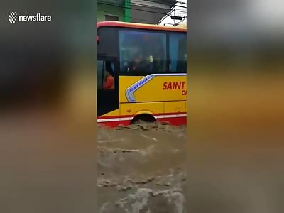 Buses struggle as Philippines storm turn road into rading river...