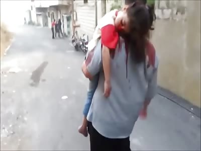 Man carrying his little daughter who took shot in the face while mother cries inconsolably