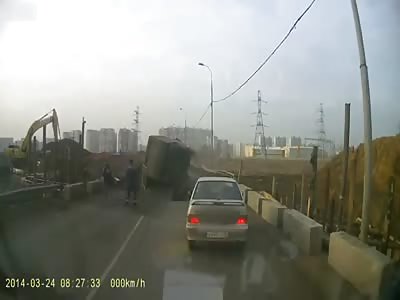 Russia: Car crushed by truck after road collapses.